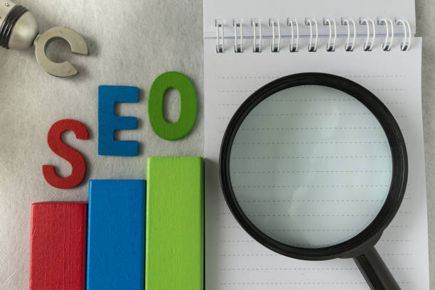 istock Search engine optimization concept as colorful wooden block as analysis chart with alphabet abbreviation SEO and magnification glass 692676402