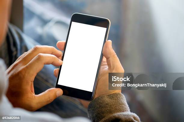 Man Holding Smart Phone With Blurred Background Stock Photo - Download Image Now - Telephone, Mobile Phone, Hand