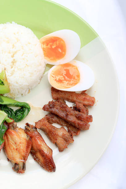 stir fried vegetables, Hard-boiled egg, Fried pork and Fried chicken wings with thai jasmine rice on dish. Thai food.stir fried vegetables, Hard-boiled egg, Fried pork and Fried chicken wings with thai jasmine rice on dish. Thai food.