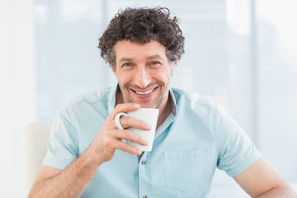 istock Smiling casual businessman sitting at desk 692698920