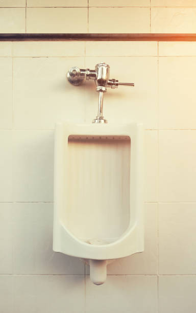 Urinal Tile Wall White urinal for men on tile wall in toilet. flushing valve public restroom toilet stock pictures, royalty-free photos & images