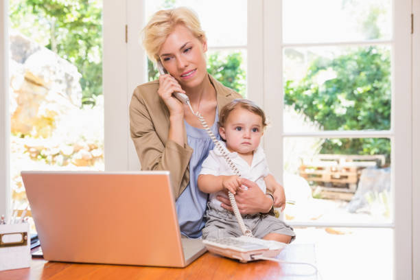 istock Pretty blonde woman with his son phoning and using laptop 692711510