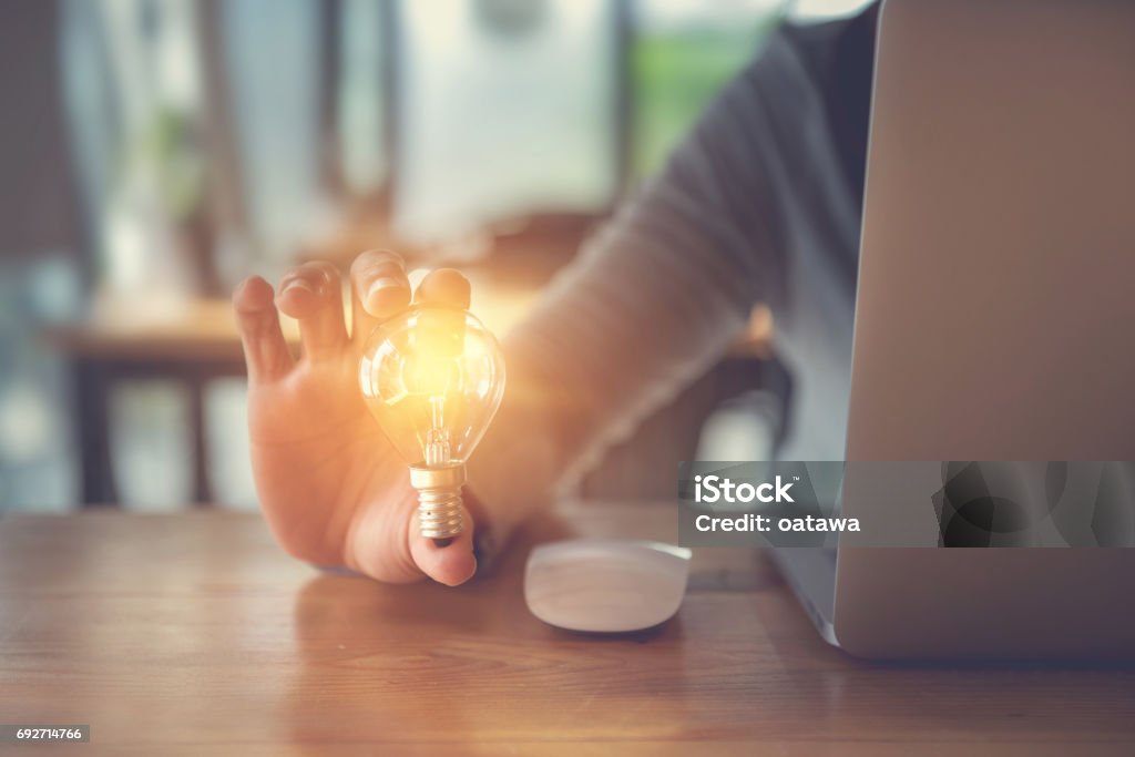 New ideas with innovation and creativity concept. New ideas with innovation and creativity concept, Young women hand holding light bulb. Light Bulb Stock Photo