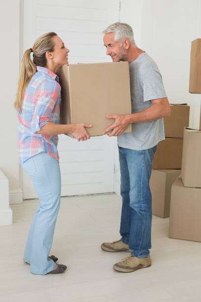 istock Happy couple carrying cardboard moving boxes 692718304