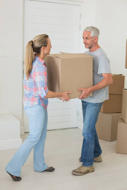 istock Happy couple carrying cardboard moving boxes 692720452