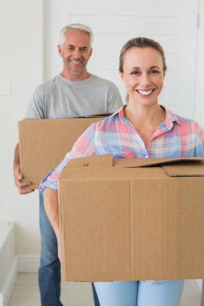 istock Happy couple carrying cardboard moving boxes 692720466