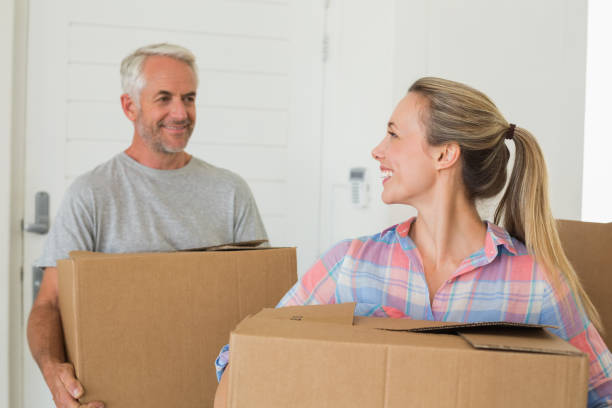 istock Happy couple carrying cardboard moving boxes 692720562