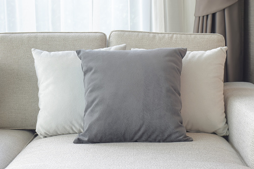 Gray and white pillows on beige sofa