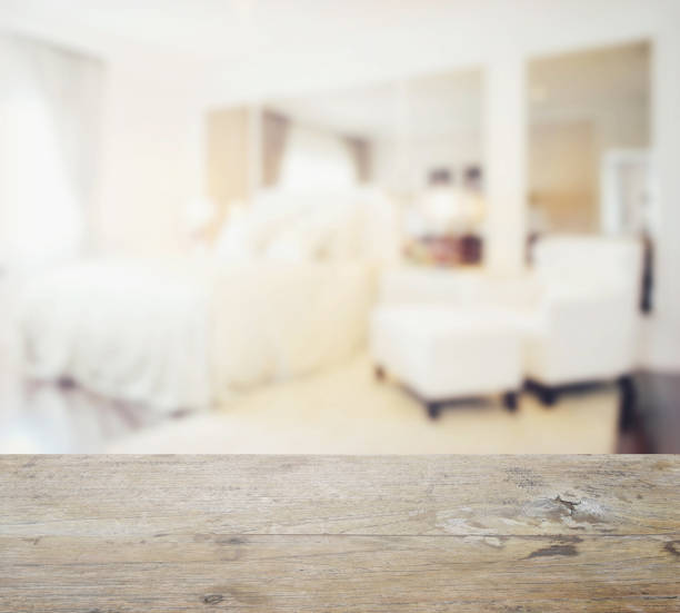 istock wooden table top with blur of modern bedroom interior 692721122