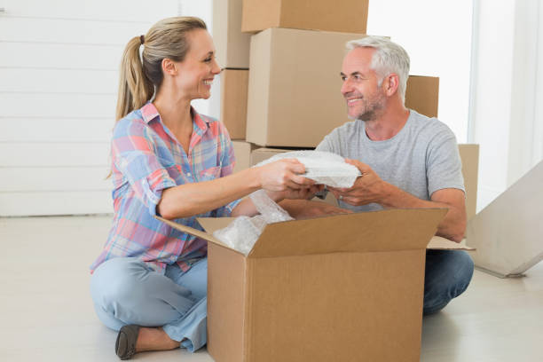 istock Happy couple unpacking cardboard moving boxes 692721252