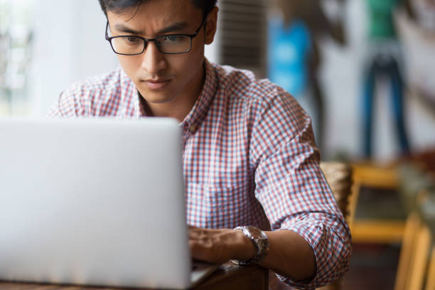 istock Concentrated young man typing on laptop in cafe 692732476