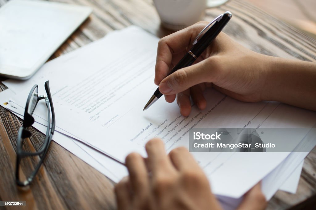 Examen de documentos en mesa de empresario - Foto de stock de Formulario de solicitud libre de derechos