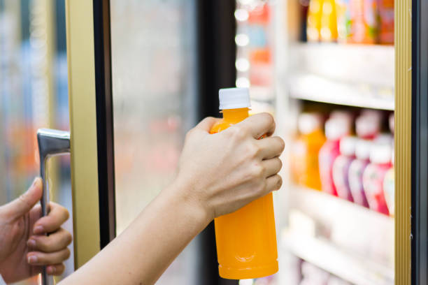 istock woman's hand open convenience store refrigerator shelves and pick product 692739572