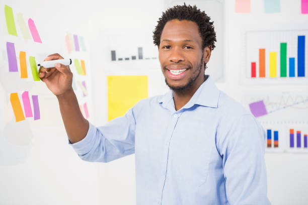 istock Young smiling businessman writing on sticky notes 692740958