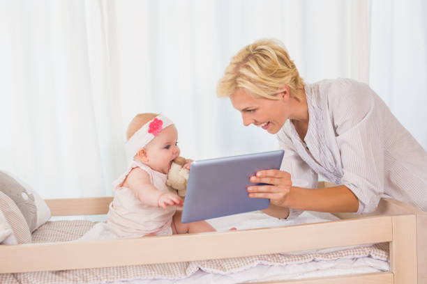 istock Happy mother with her baby girl using digital tablet 692744176