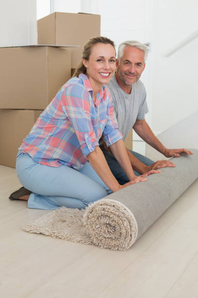 istock Happy couple rolling out new rug 692751128