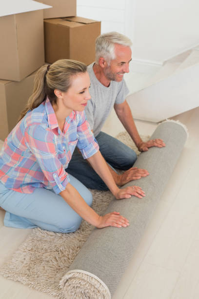 istock Happy couple rolling out new rug 692751382