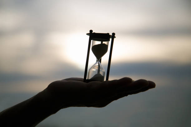 istock Hourglass on hand at dawn time 692756142