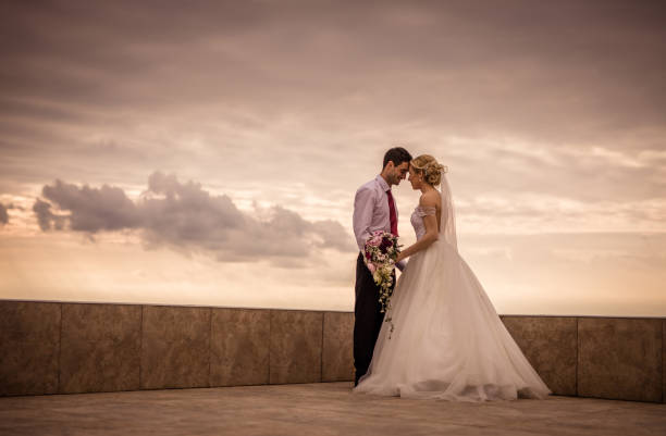Young happy married couple standing face to face on a rooftop.