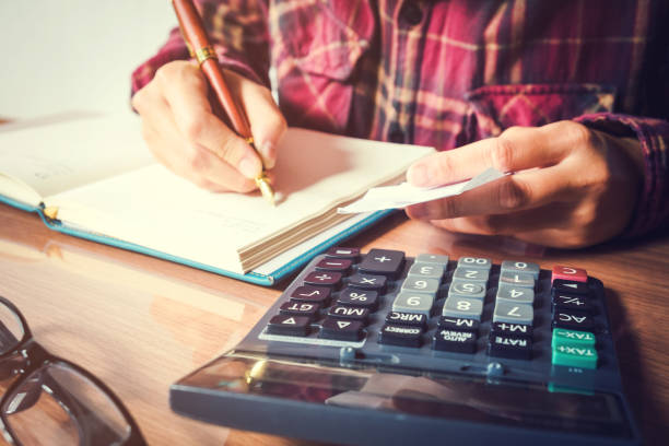 istock Businessman's hands with calculator counting making notes at home 692768884