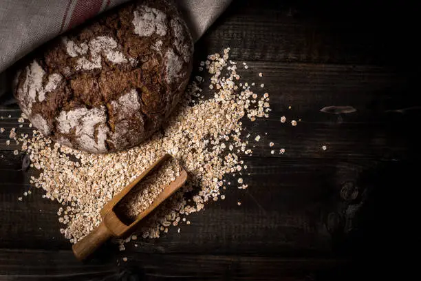 Traditional Whole Grain Rye Bread on Dark Wooden Table Background