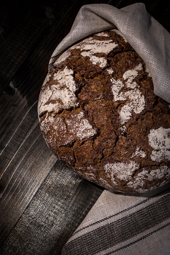 Traditional Whole Grain Rye Bread on Dark Wooden Table Background