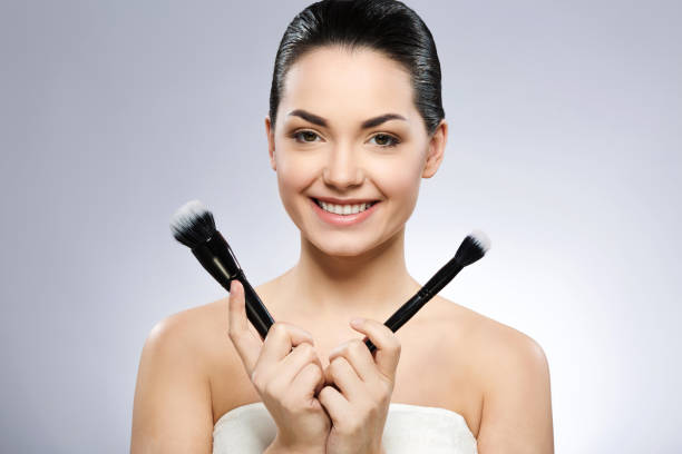 istock Lovely girl holding make up brushes 692775118