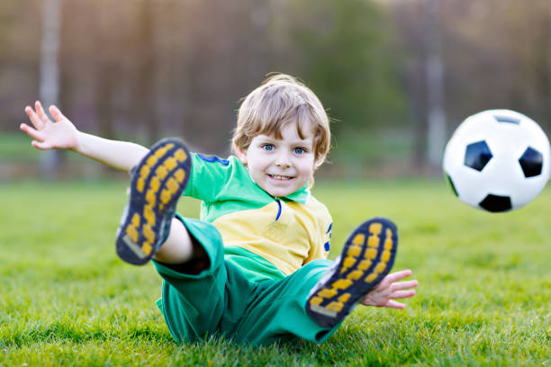 kleine süße kind junge von 4 spielen fußball mit fußball auf feld, im freien - playing field goalie soccer player little boys stock-fotos und bilder