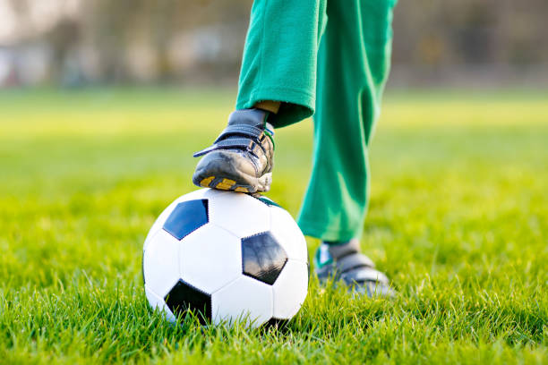 kleine süße kind junge von 4 spielen fußball mit fußball auf feld, im freien - playing field goalie soccer player little boys stock-fotos und bilder