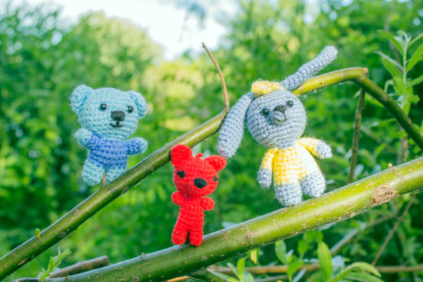 istock Toy teddy bear, fox and hare on a green branch of a tree 692778530