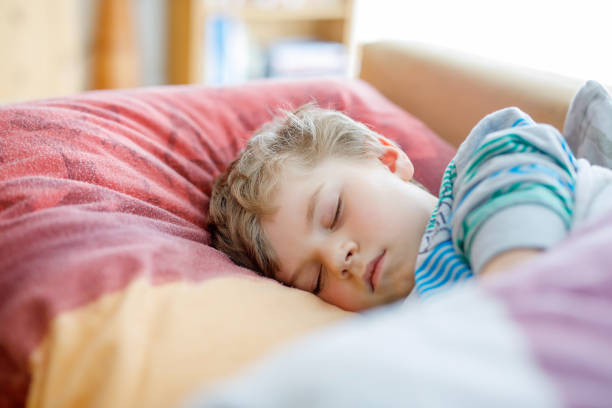 istock Little sad preschool kid boy sleeping. Tired schoolchild resting after school classes. 692778852