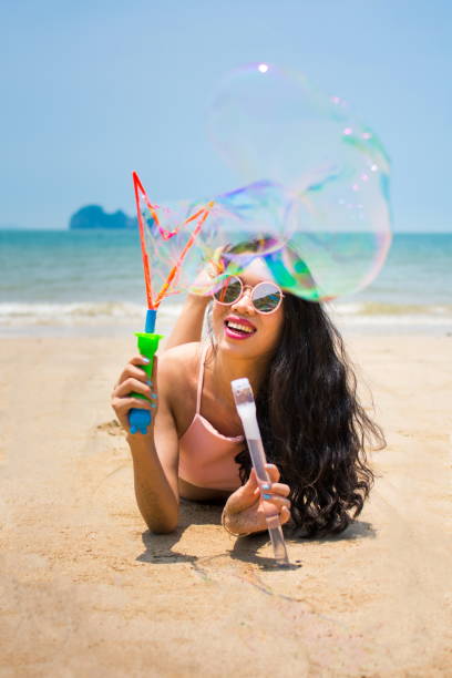 istock Girl making soap bubbles on the beach 692782774