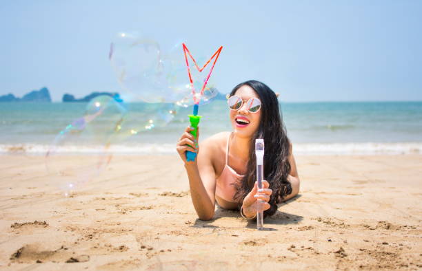 istock Girl making soap bubbles on the beach 692783236