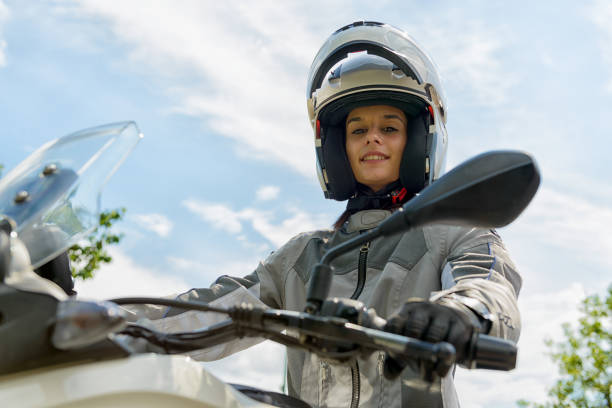 istock girl sits on a motorcycle and has a helmet on his head 692783330