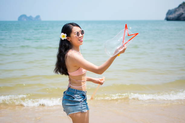 Girl making soap bubbles on the beach