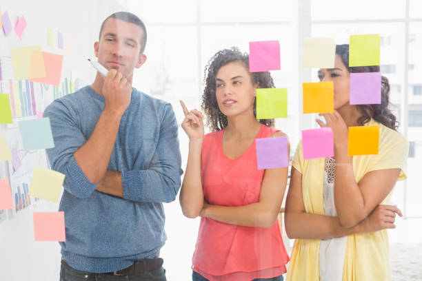 istock Concentrated coworkers pointing sticky notes 692786550