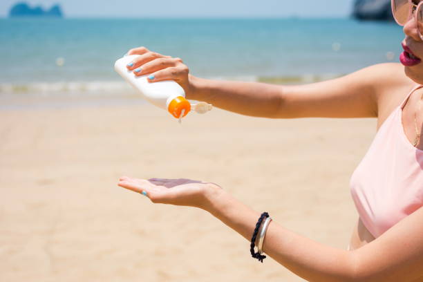 istock Girl applying sun lotion on the beach 692790912