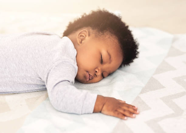 Dreaming cuddly dreams Shot of a little baby boy sleeping on a bed baby sleeping bedding bed stock pictures, royalty-free photos & images