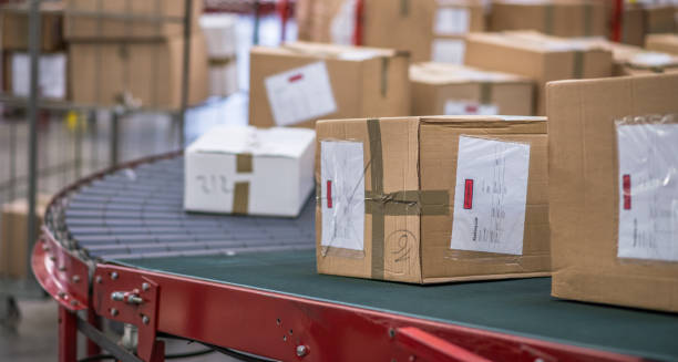 paquete de cajas de cartón en cinta transportadora - oficina de correos fotografías e imágenes de stock