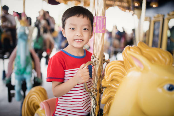 istock Child having fun riding on a colorful carnival carousel 692794116