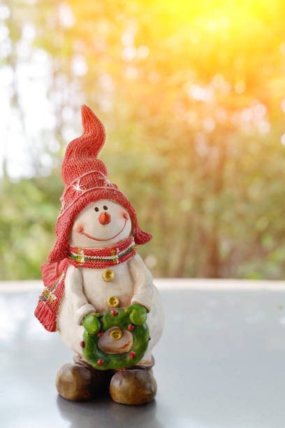 istock Happy snowman with red hat holding a wreath 692794246
