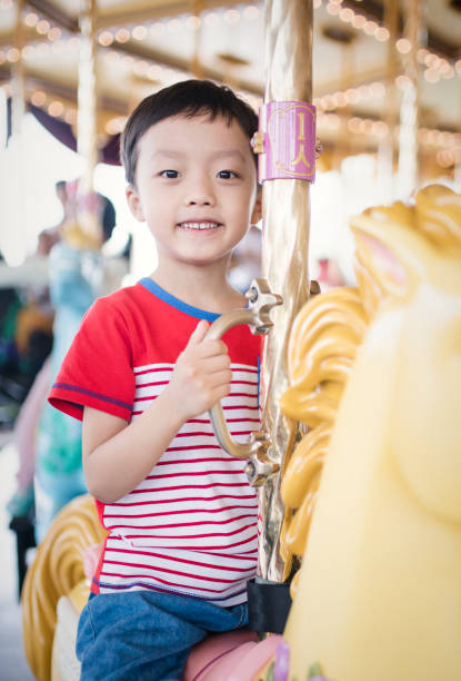 istock Child having fun riding on a colorful carnival carousel 692794420