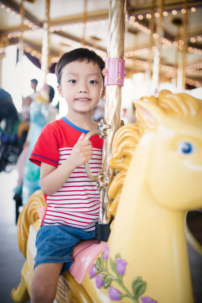 istock Child having fun riding on a colorful carnival carousel 692794458