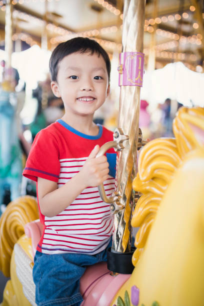 istock Child having fun riding on a colorful carnival carousel 692794652
