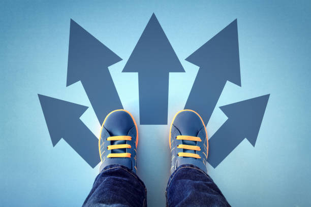 Taking decisions for the future Taking decisions for the future child standing with many direction arrow choices, left, right or move forward kids goal setting stock pictures, royalty-free photos & images