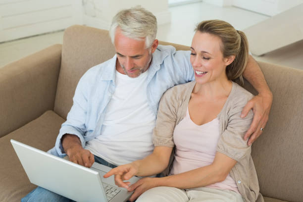 istock Happy couple using the laptop together on the couch 692798538