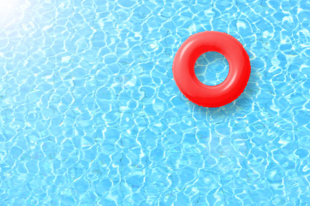 istock red swimming pool ring float in blue water and sun bright. concept color summer. 692812526