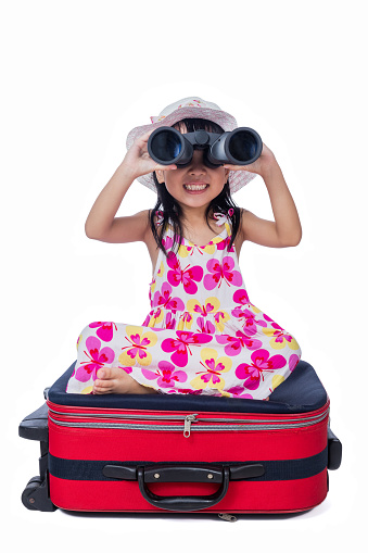 Happy Asian Little Chinese girl playing with suitcase and telescope in isolated white background