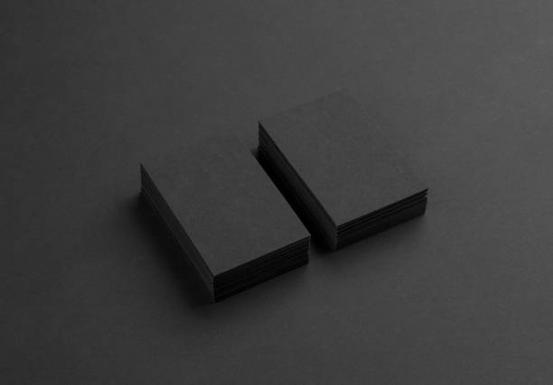 istock Black business cards isolated on black background 692814010