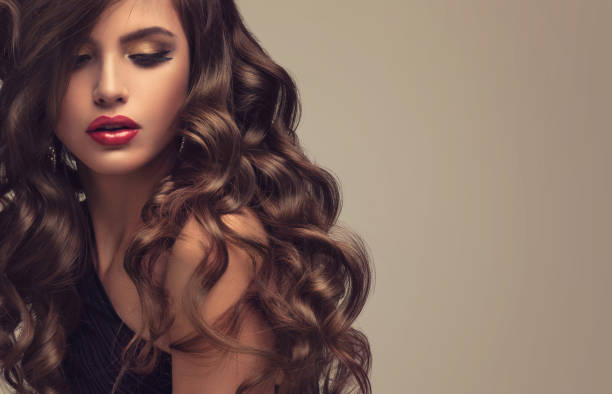 istock Young attractive brunette with voluminous, shiny and curly hairstyle. 692814130